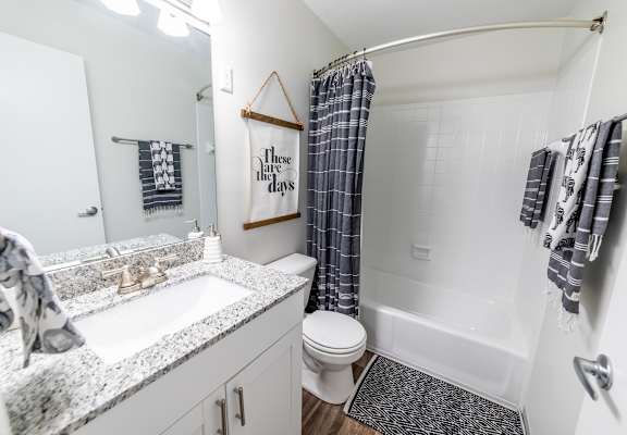 A bathroom with a toilet, sink, and shower.