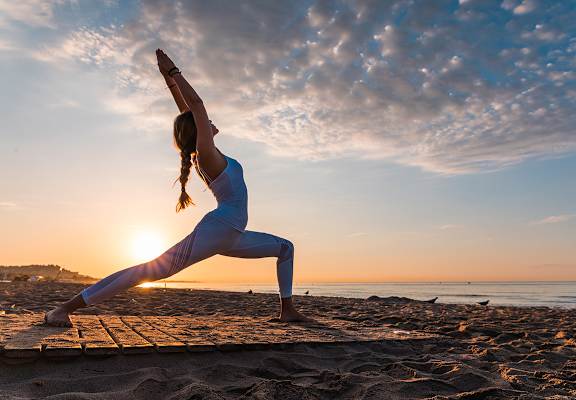 Lifestyle photo of woman doing yoga at the beach at Mission Pointe Apartments, Jacksonville, Florida