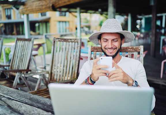 Lifestyle photo of a man working on his cell phone and computer at Sanctuary Cove, North Lauderdale, 33068
