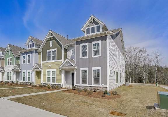 a row of houses in a neighborhood with a blue sky in the background