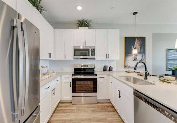 a kitchen with white cabinets and stainless steel appliances