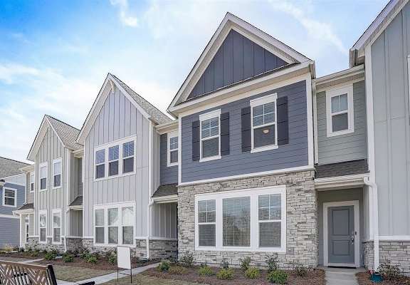 a row of townhomes with gray siding and a gray door