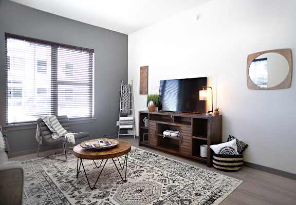 a living room with a tv and a couch and a table  at The Liberty Lofts, Gainesville, TX