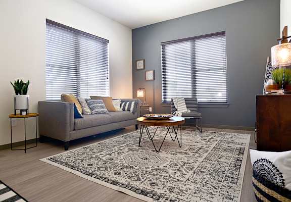 a living room with two windows and a couch and a rug  at The Liberty Lofts, Gainesville, TX