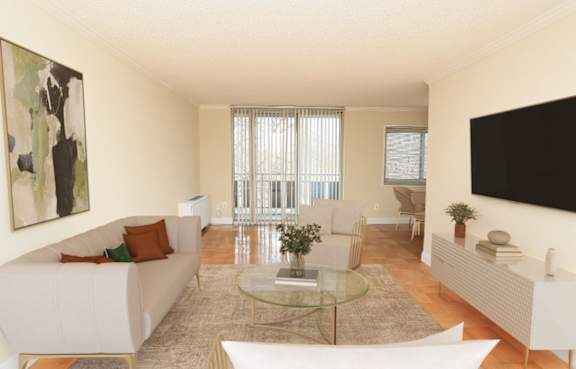 A living room with a white couch and a glass coffee table.