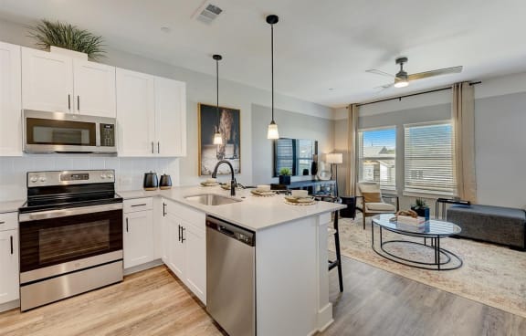 a kitchen with white cabinets and stainless steel appliances