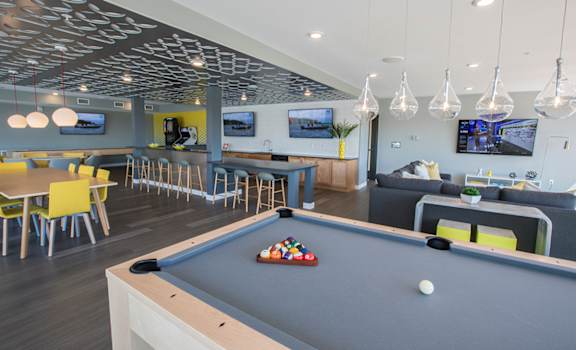 a games room with a pool table and chairs