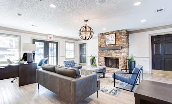 A living room with a grey couch and a fireplace at Barcelo at East Cobb Apartments, Georgia