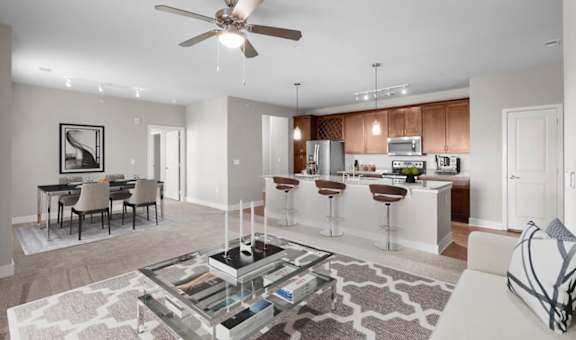 a living room and kitchen with a ceiling fan