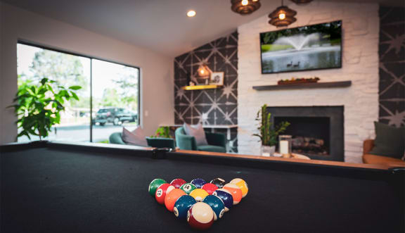 a pool table in front of a fireplace in a resident clubhouse  at Ascent at Farmington Hills, Farmington Hills