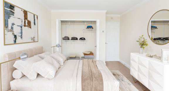 A bedroom with a bed, dresser, and mirror.