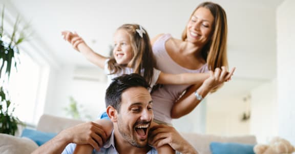 a man and woman sitting on a couch with their daughters