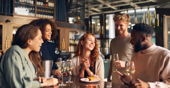 group of people at a bar talking and drinking wine at Tides on Southern, Arizona, 85204