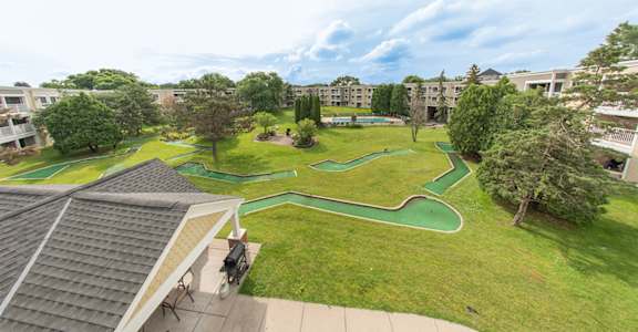 A green lawn with a small playground in the middle.