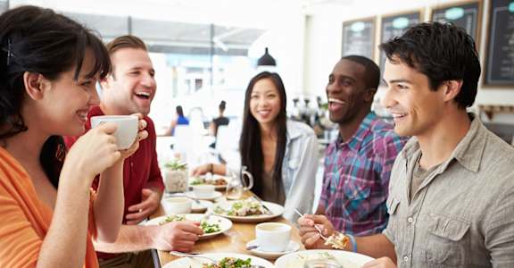 a group of people sitting around a table eating food
