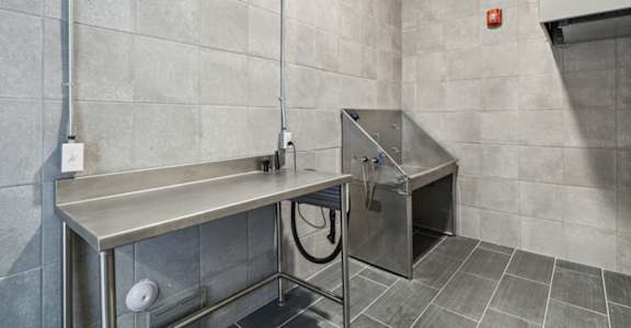 A stainless steel sink in a tiled bathroom.