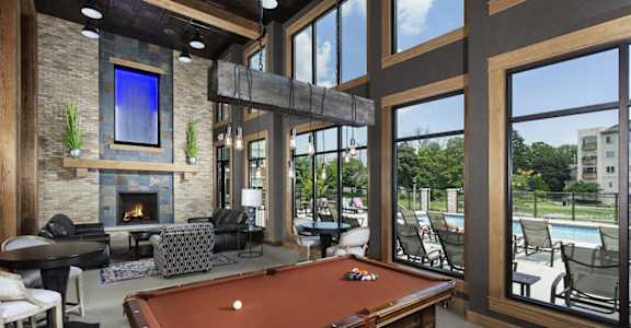a clubhouse with a pool table and a fireplace