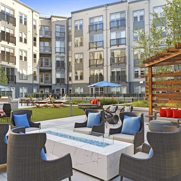 A patio with a table and chairs is surrounded by apartment buildings.