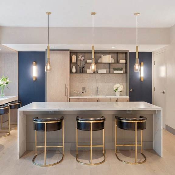 A modern kitchen with a bar area and stools.