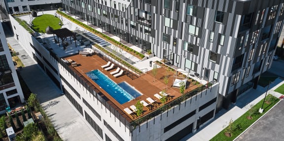 an aerial view of a building with a pool in the middle