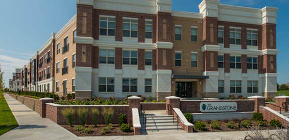 a large brick building with a sign in front of it  at The Grandstone, Mason