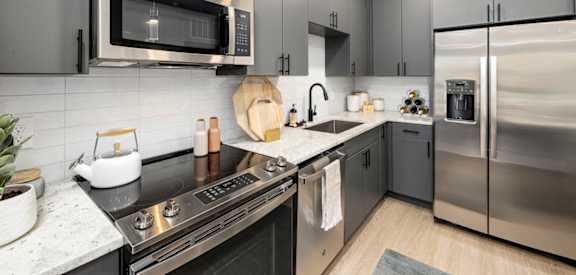 a modern kitchen with stainless steel appliances and black counter tops