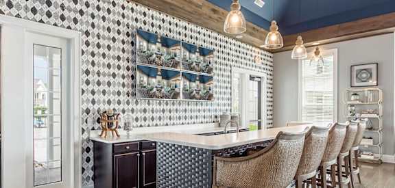 a kitchen with a bar and chairs in a house