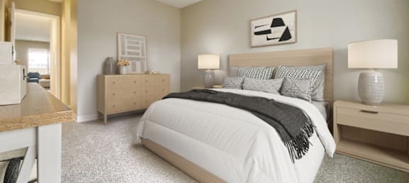 A bedroom with a large bed and a nightstand with a lamp.