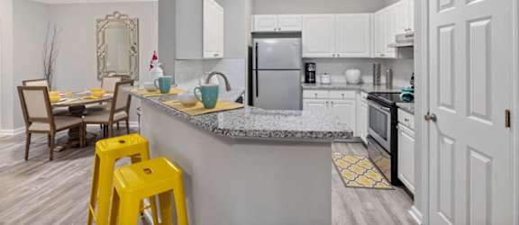 a kitchen with a bar and yellow stools