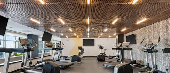 A gym with treadmills, elliptical machines, and other exercise equipment.