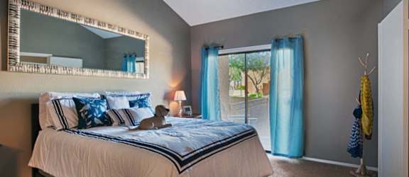 A bedroom with a large bed and a mirror on the wall.