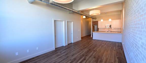 a view of a living room and kitchen in an empty apartment