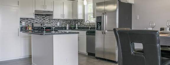 a kitchen with white cabinets and stainless steel appliances
