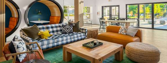 A modern living room with a blue and white sofa, a wooden coffee table, and a green rug.