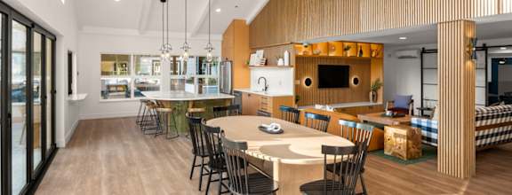 A modern dining room with a long table and chairs.