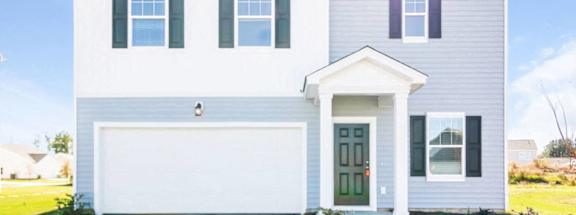 A two-story house with a white garage door and a green front door.