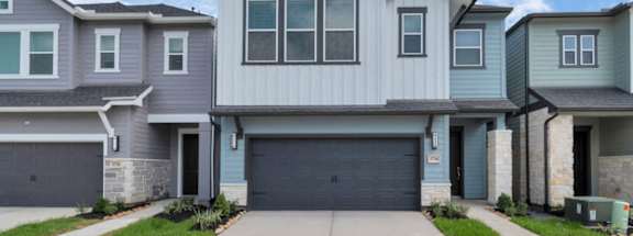 A row of houses with garages in front.