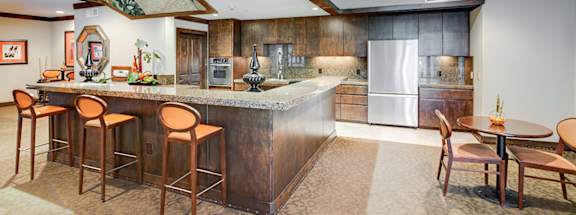A kitchen with a bar area and a dining table.