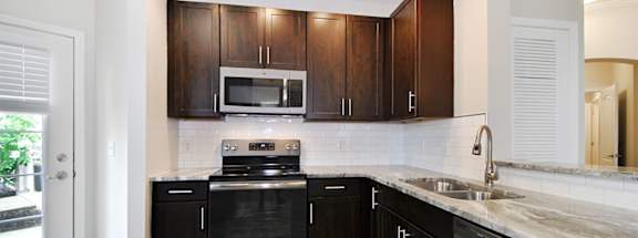 a kitchen with dark wood cabinets and white countertops