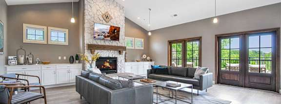 a living room with gray walls and a stone fireplace