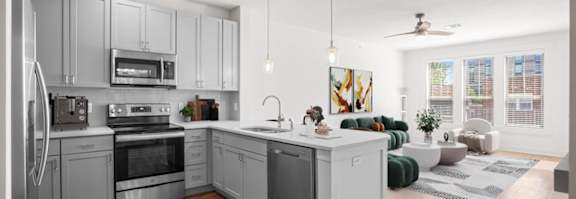 A modern kitchen with wooden floors and stainless steel appliances.at Mirabelle Luxury Apartments, Kansas City, 64111