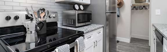 A kitchen with black countertops and white cabinets. at The Heights Apartments, Cincinnati, 45220