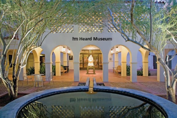 the front of the head museum with a pool and trees