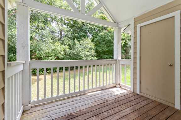 A white wooden porch with a door and a window.