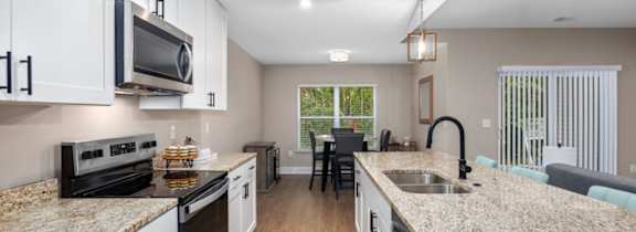 A kitchen with granite countertops and white cabinets.