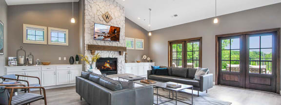 a living room with gray walls and a stone fireplace