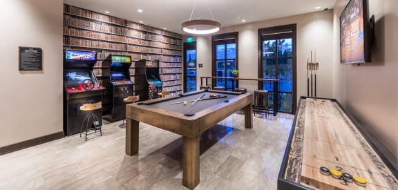 a game room with a pool table and video games