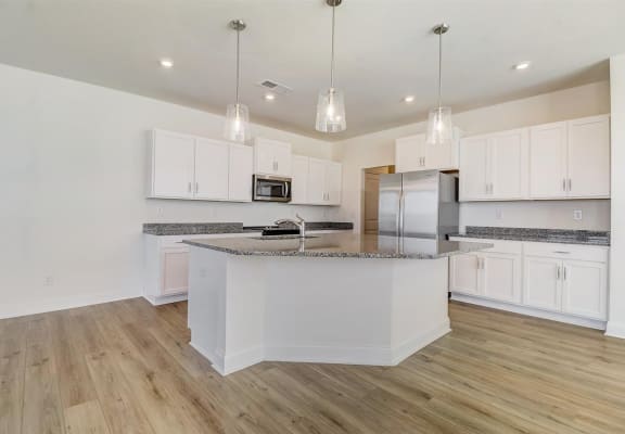a kitchen with white cabinets and a large island with granite countertops