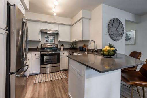 an open kitchen with stainless steel appliances and a large clock