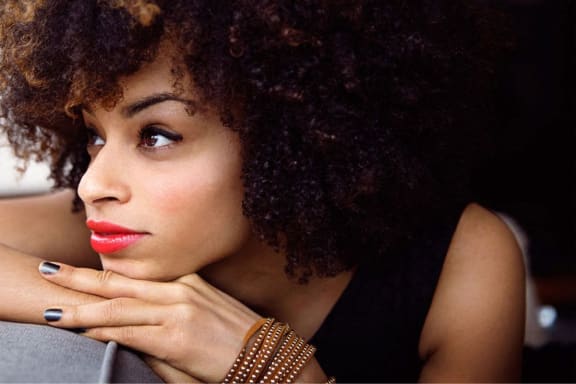 curly-haired woman looking into the distance